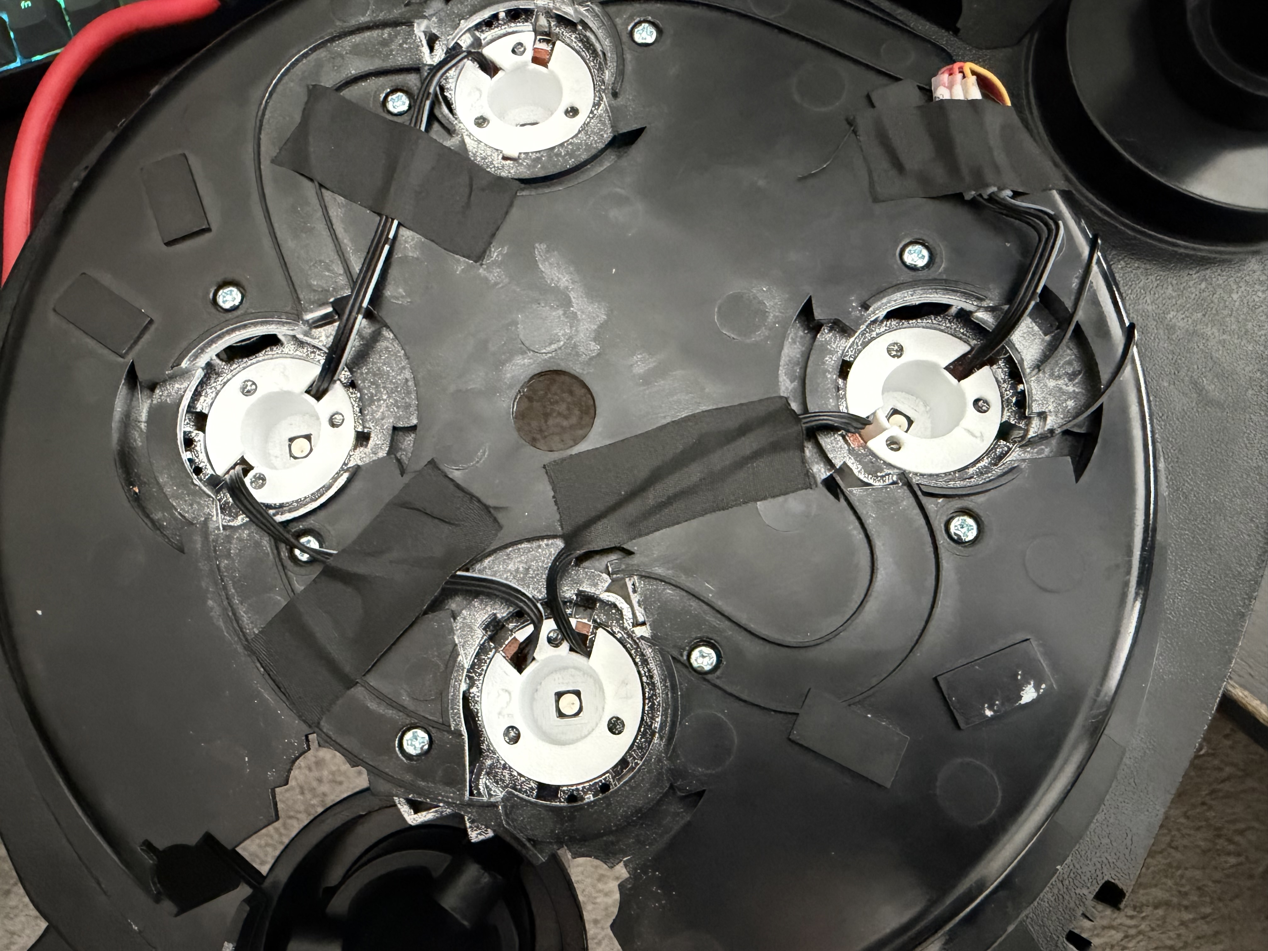 Four reflector cup wires secured to the inside of the cyclotron lid with black tape